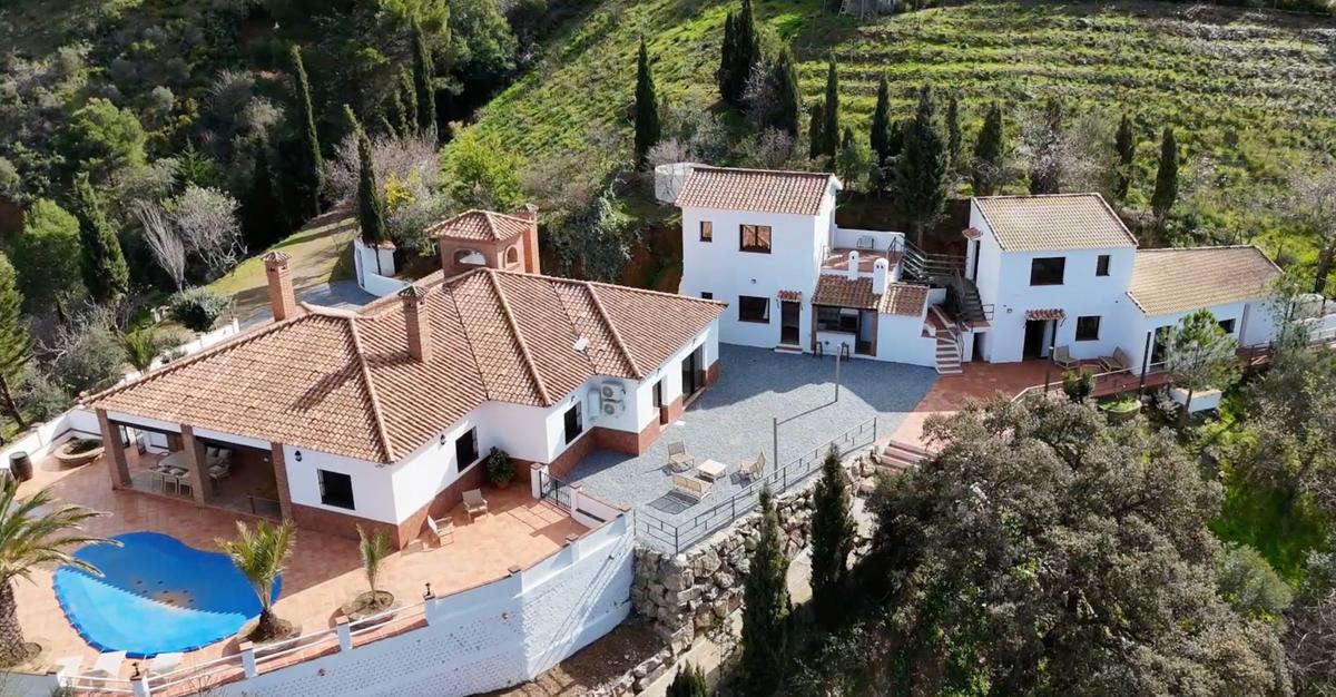 Luchtfoto van Finca Vida Feliz in Málaga — zwembad, terrassen en witte gebouwen omgeven door natuur